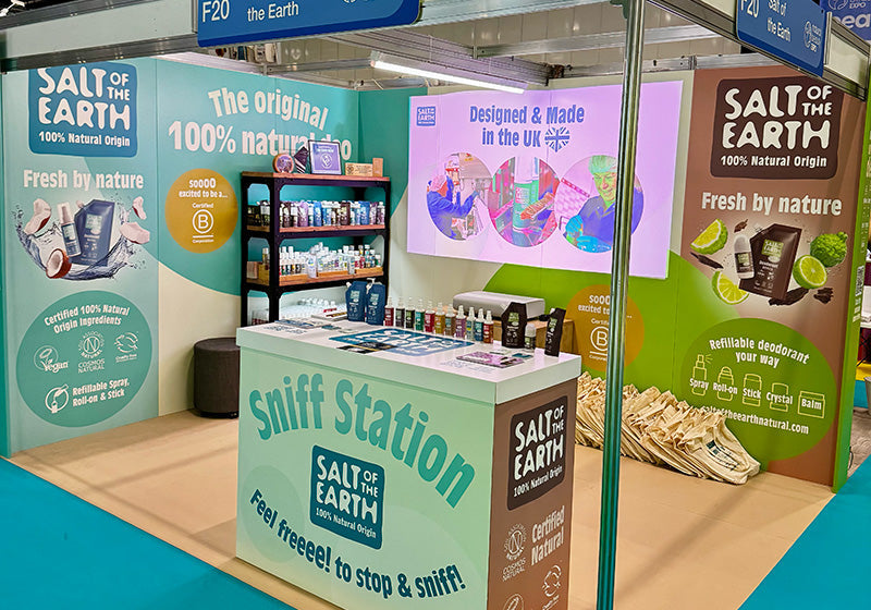 Salt of the Earth completed exhibition stand at NOPE 2025, featuring cardboard display panels, our sniff station, product shelving, certification logos, and 100% natural origin messaging alongside our B Corp certification.