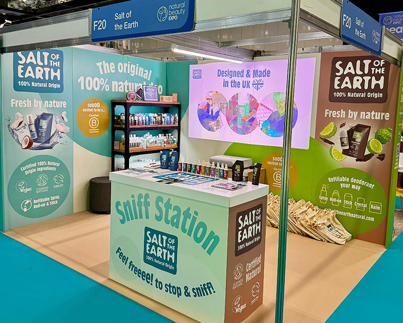 Salt of the Earth completed exhibition stand at NOPE 2025, featuring cardboard display panels, our sniff station, product shelving, certification logos, and 100% natural origin messaging alongside our B Corp certification.